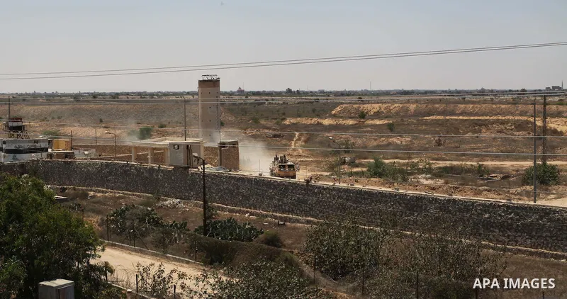 A picture taken on June 28, 2017 from the Gaza strip border-town of Rafah shows Egyptian border guards patrolling on the other side of the border while riding in an armoured personnel carrier. Photo by Ramadan El-agha