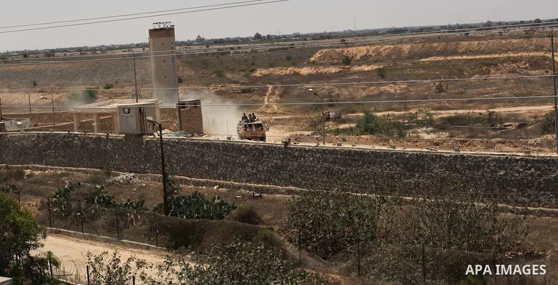 A picture taken on June 28, 2017 from the Gaza strip border-town of Rafah shows Egyptian border guards patrolling on the other side of the border while riding in an armoured personnel carrier. Photo by Ramadan El-agha