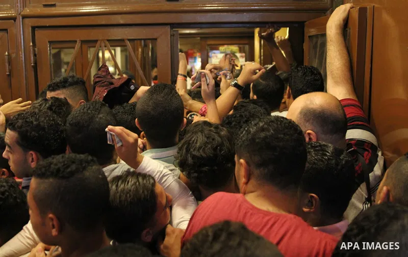 Egyptians gather around the cinema windows to buy tickets on the third day of Eid al-Fitr holiday which marks the end of the Muslim holy month of Ramadan, in Cairo, Egypt, on June 27, 2017. Photo by Amr Sayed
