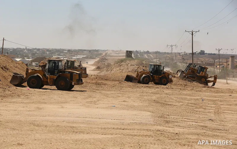 Parliment Palestinian bulldozers clear an area as Hamas begins creating a large buffer zone on the border with Egypt in the southern Gaza strip town of Rafah, on June 29, 2017. The buffer zone is expected to extend for a...