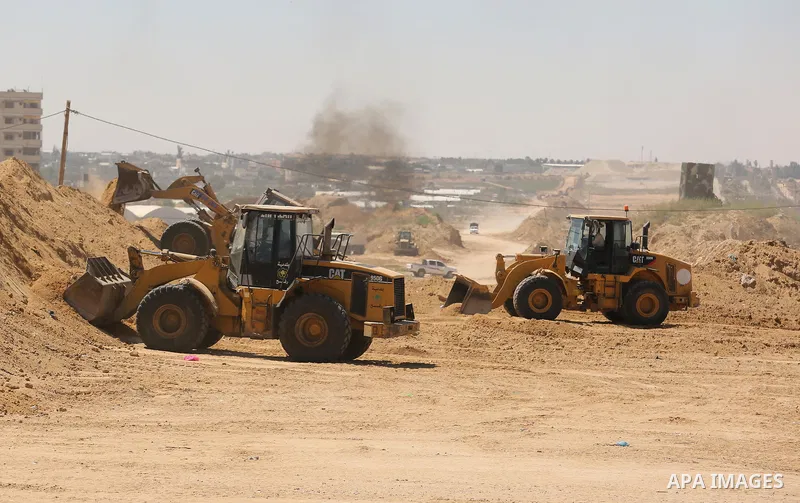 Parliment Palestinian bulldozers clear an area as Hamas begins creating a large buffer zone on the border with Egypt in the southern Gaza strip town of Rafah, on June 29, 2017. The buffer zone is expected to extend for a...