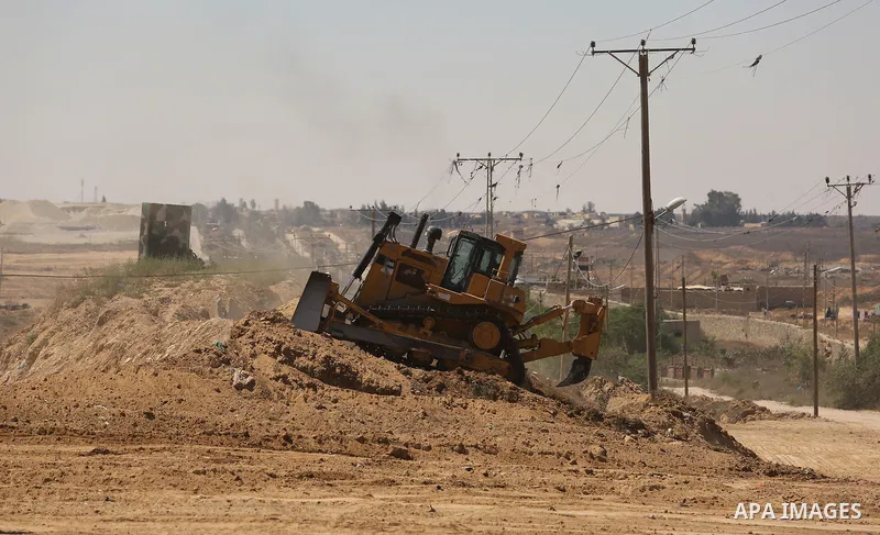 Parliment Palestinian bulldozers clear an area as Hamas begins creating a large buffer zone on the border with Egypt in the southern Gaza strip town of Rafah, on June 29, 2017. The buffer zone is expected to extend for a...