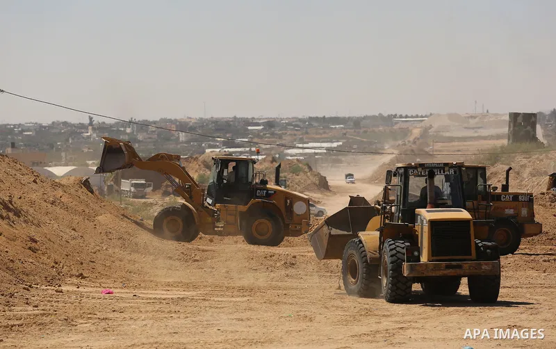 Parliment Palestinian bulldozers clear an area as Hamas begins creating a large buffer zone on the border with Egypt in the southern Gaza strip town of Rafah, on June 29, 2017. The buffer zone is expected to extend for a...