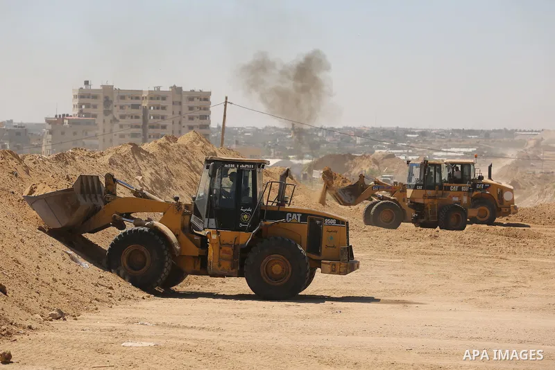 Parliment Palestinian bulldozers clear an area as Hamas begins creating a large buffer zone on the border with Egypt in the southern Gaza strip town of Rafah, on June 29, 2017. The buffer zone is expected to extend for a...