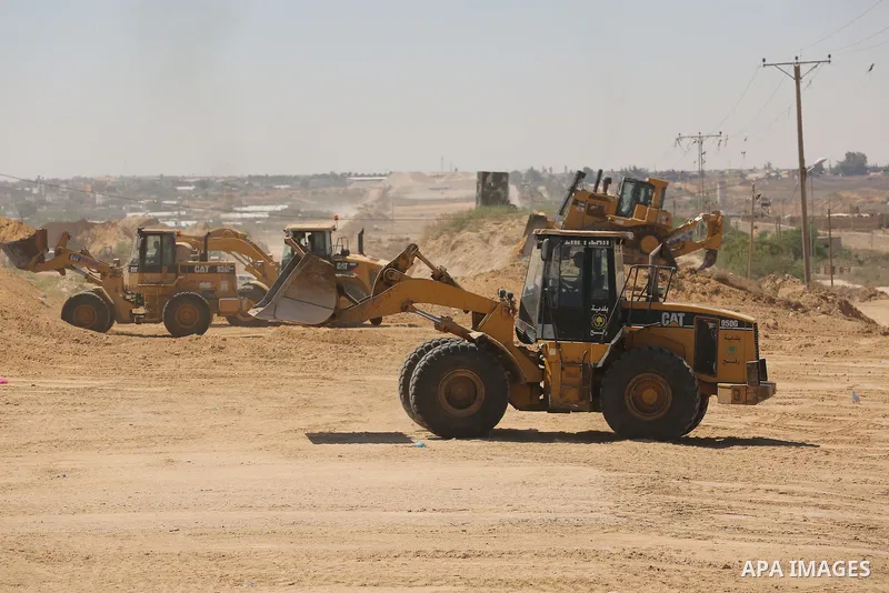 Parliment Palestinian bulldozers clear an area as Hamas begins creating a large buffer zone on the border with Egypt in the southern Gaza strip town of Rafah, on June 29, 2017. The buffer zone is expected to extend for a...