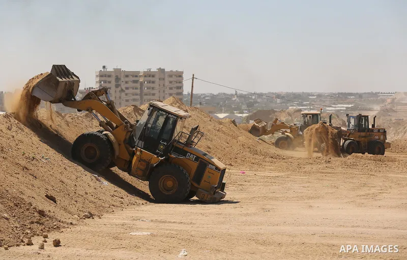 Parliment Palestinian bulldozers clear an area as Hamas begins creating a large buffer zone on the border with Egypt in the southern Gaza strip town of Rafah, on June 29, 2017. The buffer zone is expected to extend for a...