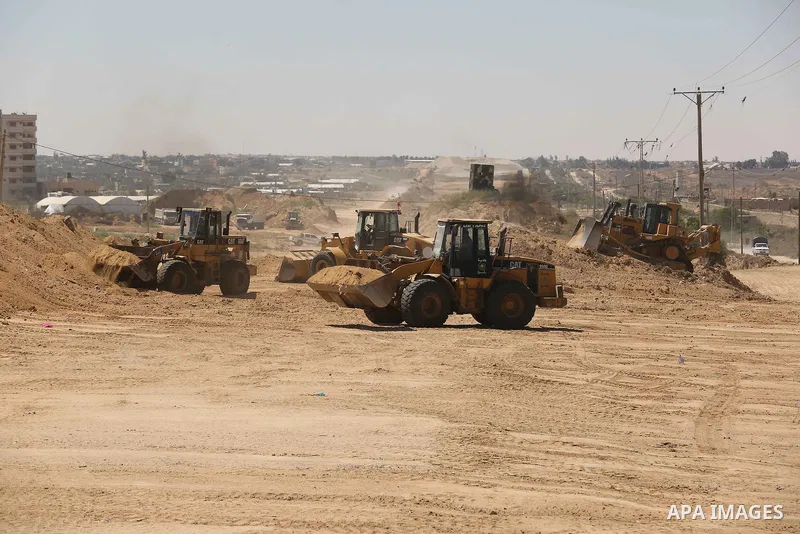 Parliment Palestinian bulldozers clear an area as Hamas begins creating a large buffer zone on the border with Egypt in the southern Gaza strip town of Rafah, on June 29, 2017. The buffer zone is expected to extend for a...