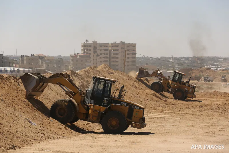 Parliment Palestinian bulldozers clear an area as Hamas begins creating a large buffer zone on the border with Egypt in the southern Gaza strip town of Rafah, on June 29, 2017. The buffer zone is expected to extend for a...