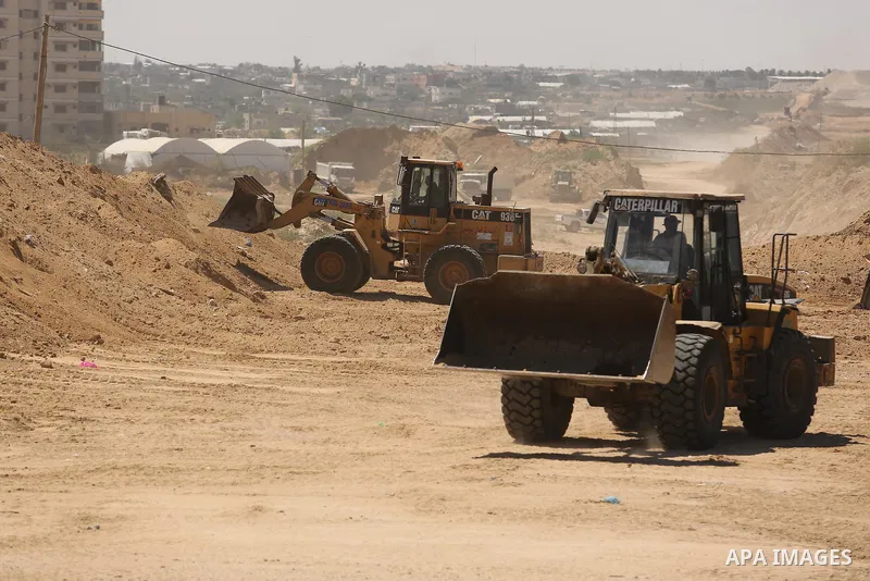 Parliment Palestinian bulldozers clear an area as Hamas begins creating a large buffer zone on the border with Egypt in the southern Gaza strip town of Rafah, on June 29, 2017. The buffer zone is expected to extend for a...