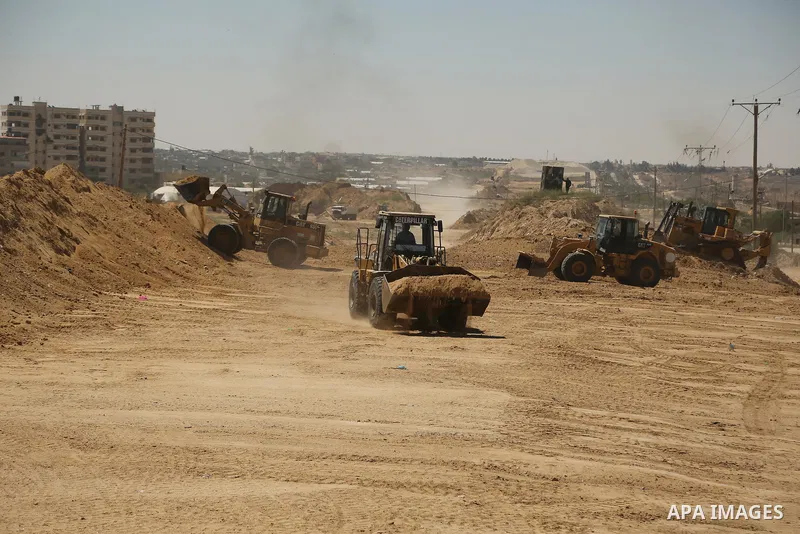 Parliment Palestinian bulldozers clear an area as Hamas begins creating a large buffer zone on the border with Egypt in the southern Gaza strip town of Rafah, on June 29, 2017. The buffer zone is expected to extend for a...