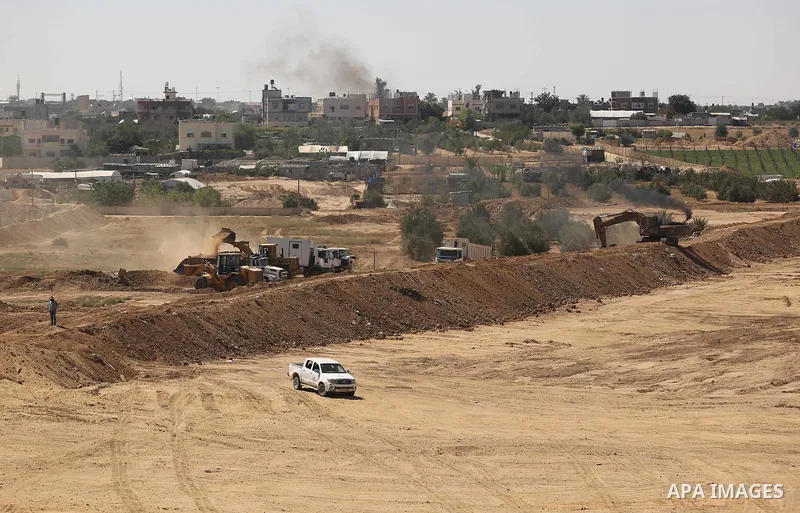 Parliment Palestinian bulldozers clear an area as Hamas begins creating a large buffer zone on the border with Egypt in the southern Gaza strip town of Rafah, on June 29, 2017. The buffer zone is expected to extend for a...