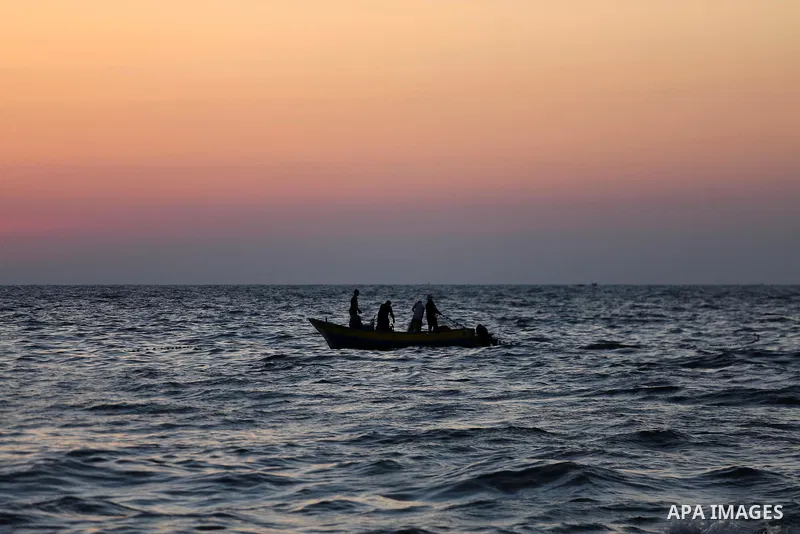 Palestinian fishermen ride a fishing boat during the sunset on the beach of Gaza city, on June 29, 2017. Photo by Mohammed Asad