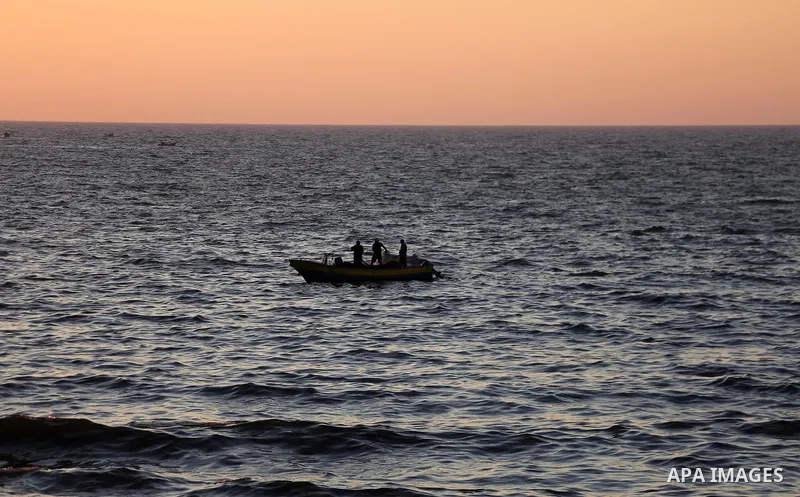 Palestinian fishermen ride a fishing boat during the sunset on the beach of Gaza city, on June 29, 2017. Photo by Mohammed Asad