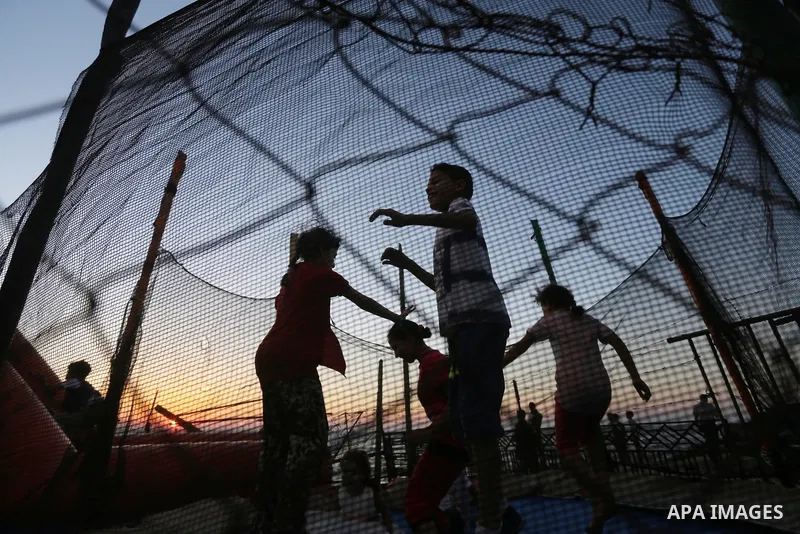 Palestinians childen play during the sunset on the beach of Gaza city, on June 29, 2017. Photo by Mohammed Asad