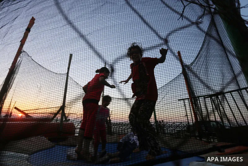 Palestinians childen play during the sunset on the beach of Gaza city, on June 29, 2017. Photo by Mohammed Asad