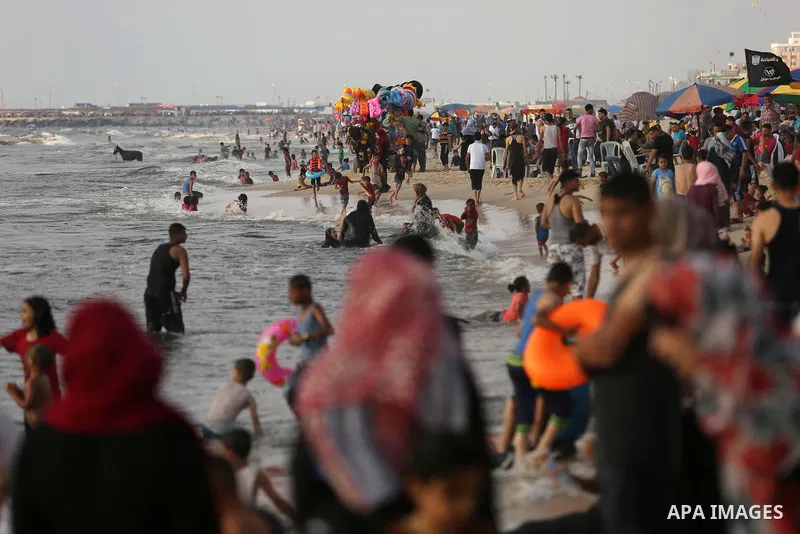 Palestinians enjoy their time at the beach of the Mediterranean sea on the coast of Gaza city, on June 30, 2017. Photo by Ashraf Amra
