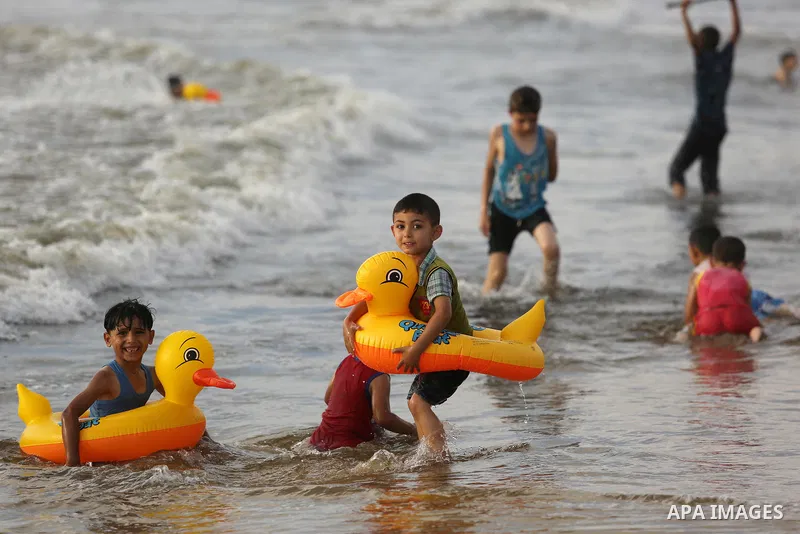 Palestinians enjoy their time at the beach of the Mediterranean sea on the coast of Gaza city, on June 30, 2017. Photo by Ashraf Amra