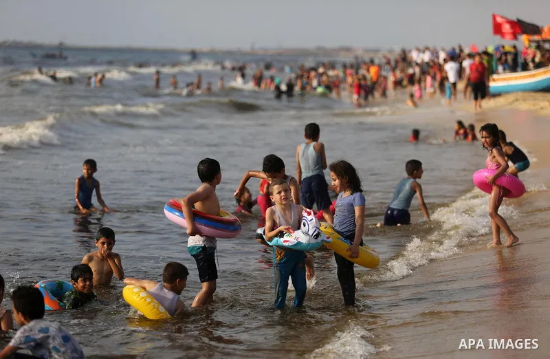 Palestinians enjoy their time at the beach of the Mediterranean sea on the coast of Gaza city, on June 30, 2017. Photo by Ashraf Amra
