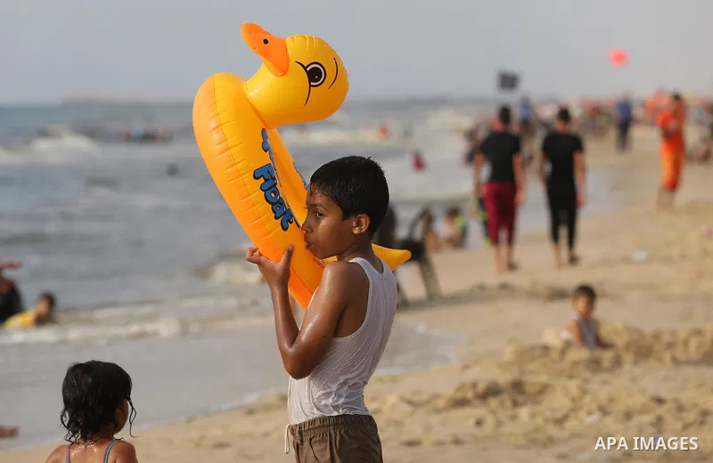 Palestinians enjoy their time at the beach of the Mediterranean sea on the coast of Gaza city, on June 30, 2017. Photo by Ashraf Amra