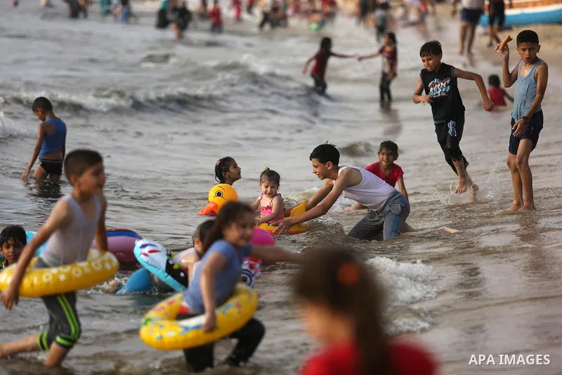 Palestinians enjoy their time at the beach of the Mediterranean sea on the coast of Gaza city, on June 30, 2017. Photo by Ashraf Amra