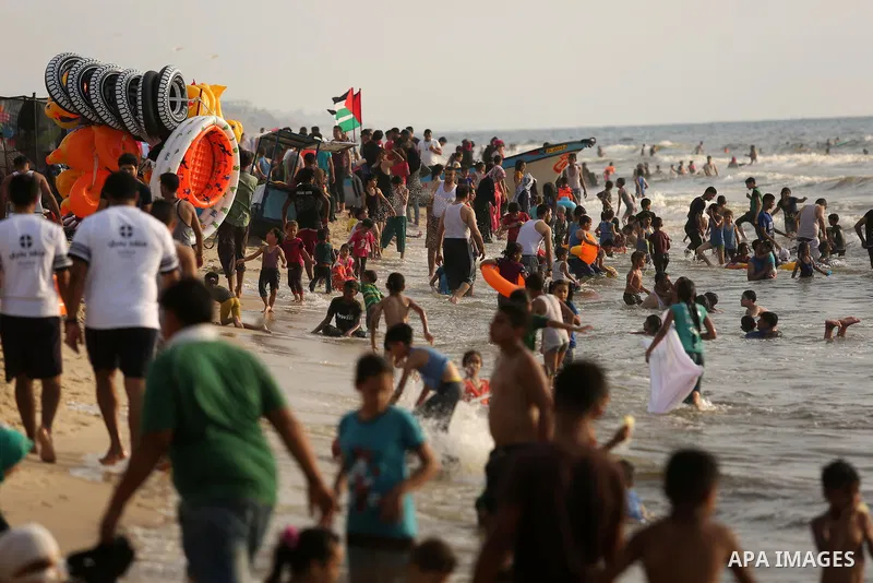 Palestinians enjoy their time at the beach of the Mediterranean sea on the coast of Gaza city, on June 30, 2017. Photo by Ashraf Amra
