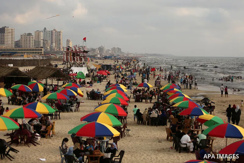 Palestinians enjoy their time at the beach of the Mediterranean sea on the coast of Gaza city, on June 30, 2017. Photo by Ashraf Amra