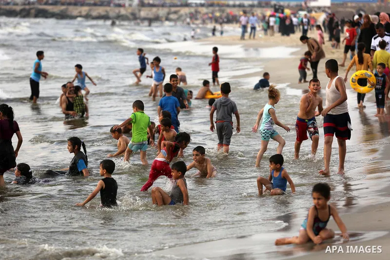 Palestinians enjoy their time at the beach of the Mediterranean sea on the coast of Gaza city, on June 30, 2017. Photo by Ashraf Amra