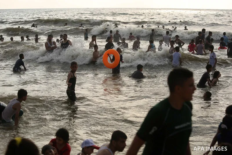 Palestinians enjoy their time at the beach of the Mediterranean sea on the coast of Gaza city, on June 30, 2017. Photo by Ashraf Amra