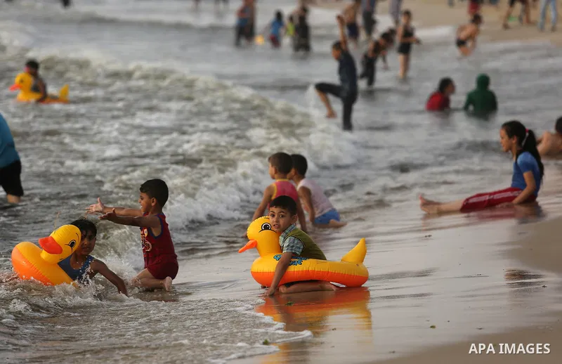 Palestinians enjoy their time at the beach of the Mediterranean sea on the coast of Gaza city, on June 30, 2017. Photo by Ashraf Amra
