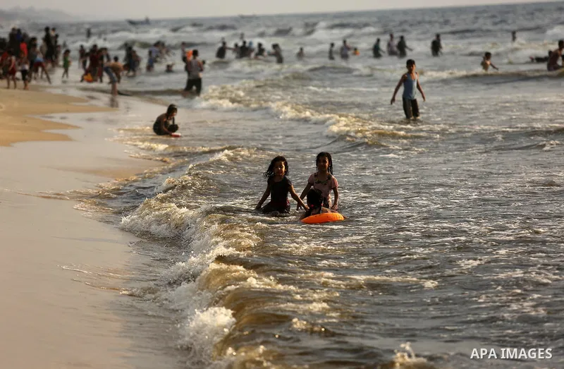 Palestinians enjoy their time at the beach of the Mediterranean sea on the coast of Gaza city, on June 30, 2017. Photo by Ashraf Amra