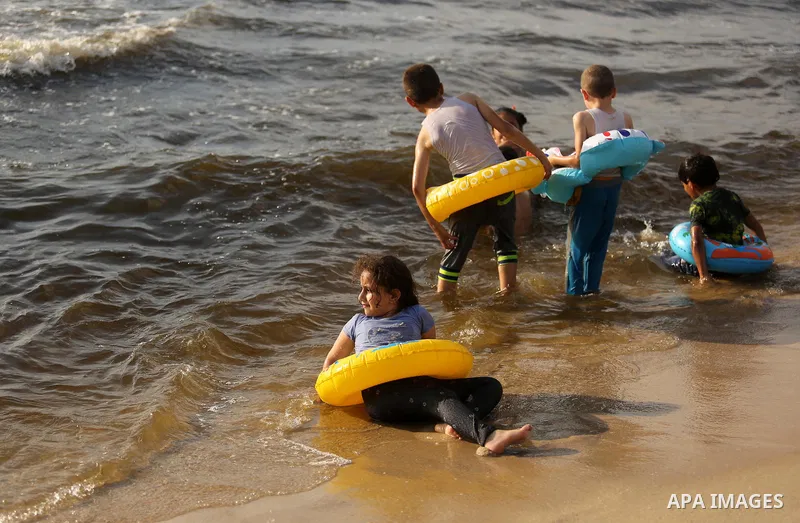 Palestinians enjoy their time at the beach of the Mediterranean sea on the coast of Gaza city, on June 30, 2017. Photo by Ashraf Amra