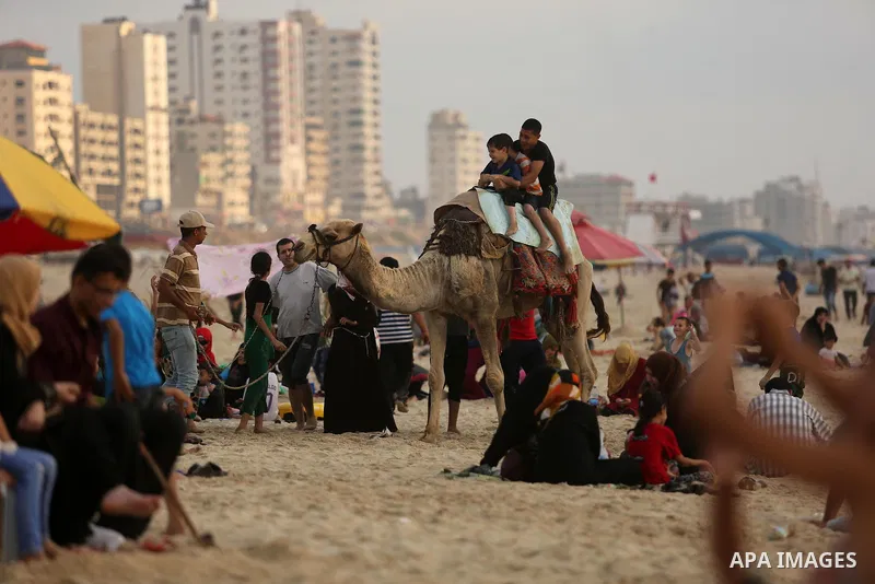 Palestinians enjoy their time at the beach of the Mediterranean sea on the coast of Gaza city, on June 30, 2017. Photo by Ashraf Amra