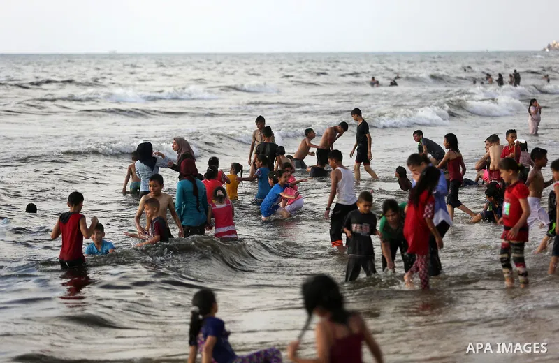 Palestinians enjoy their time at the beach of the Mediterranean sea on the coast of Gaza city, on June 30, 2017. Photo by Ashraf Amra