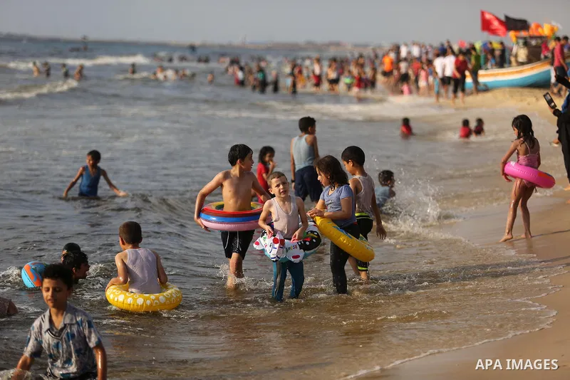 Palestinians enjoy their time at the beach of the Mediterranean sea on the coast of Gaza city, on June 30, 2017. Photo by Ashraf Amra