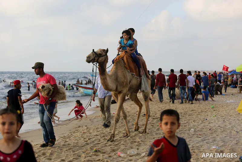 Palestinians enjoy their time at the beach of the Mediterranean sea on the coast of Gaza city, on June 30, 2017. Photo by Ashraf Amra