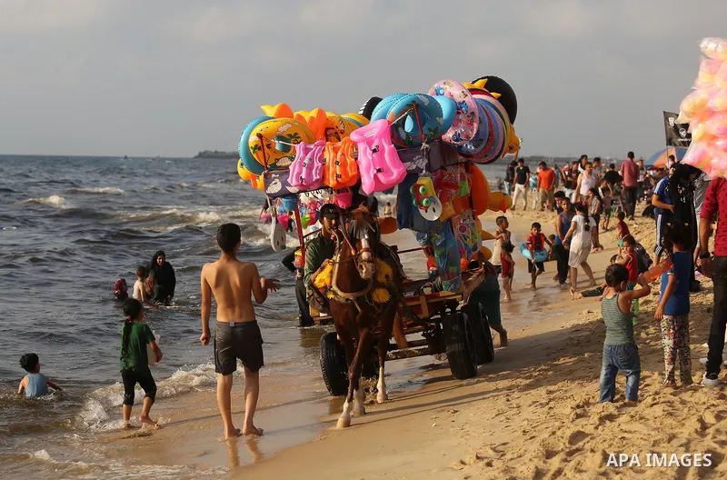 Palestinians enjoy their time at the beach of the Mediterranean sea on the coast of Gaza city, on June 30, 2017. Photo by Ashraf Amra