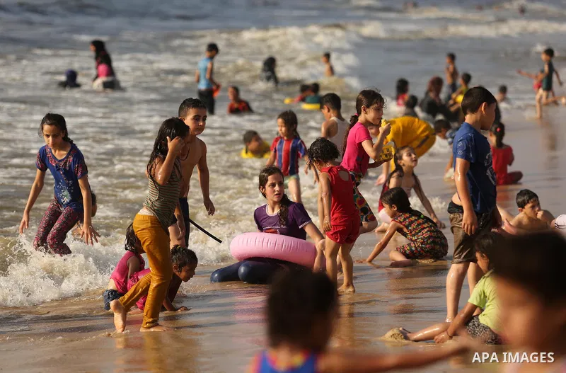 Palestinians enjoy their time at the beach of the Mediterranean sea on the coast of Gaza city, on June 30, 2017. Photo by Ashraf Amra