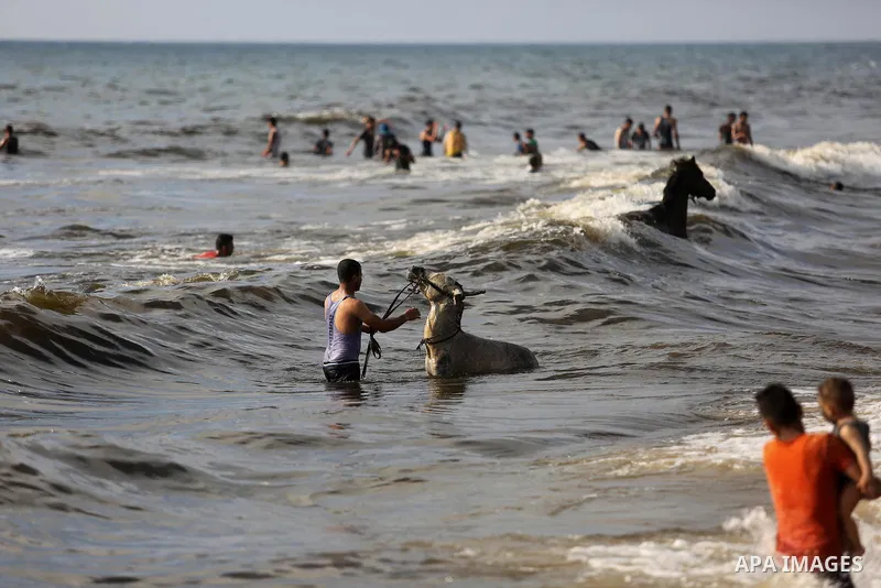Palestinians enjoy their time at the beach of the Mediterranean sea on the coast of Gaza city, on June 30, 2017. Photo by Ashraf Amra