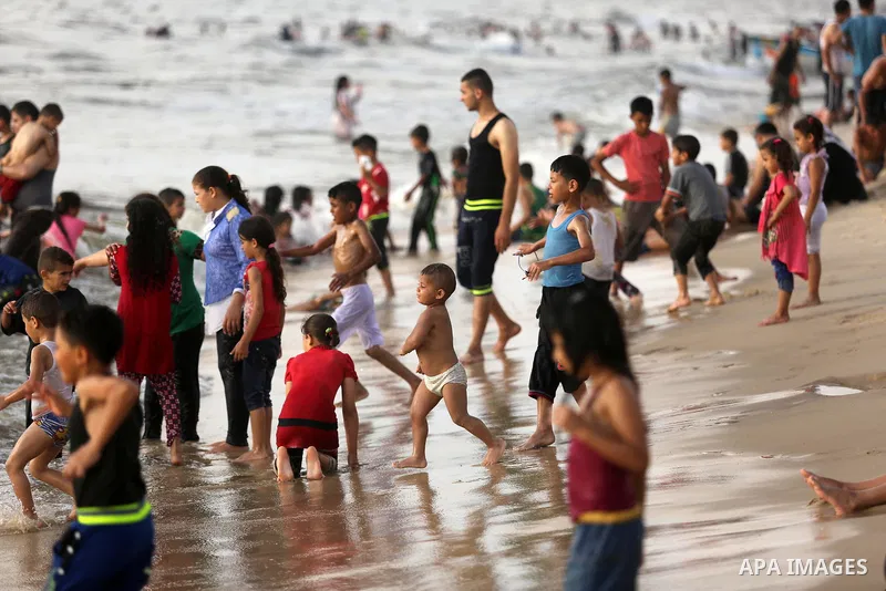 Palestinians enjoy their time at the beach of the Mediterranean sea on the coast of Gaza city, on June 30, 2017. Photo by Ashraf Amra
