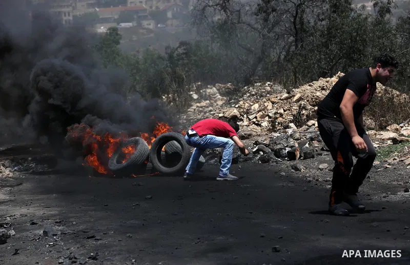 Palestinian protesters take cover during clashes with Israeli security forces following a weekly demonstration against the expropriation of Palestinian land by Israel in the village of Kfar Qaddum, near Nablus, in the oc...