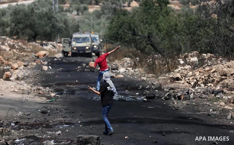 Palestinian protesters hurl stones towards Israeli security forces during clashes following a weekly demonstration against the expropriation of Palestinian land by Israel in the village of Kfar Qaddum, near Nablus, in th...