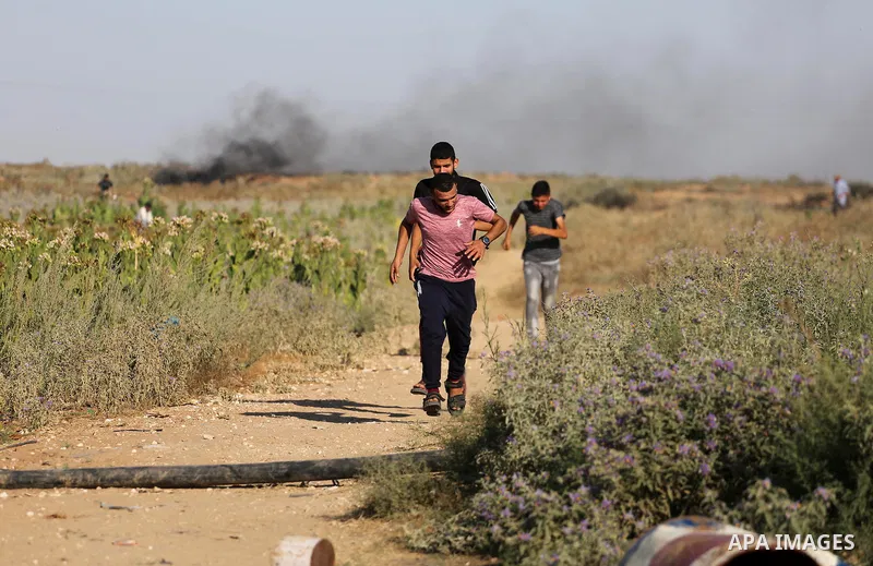 Palestinian protesters run for cover during clashes with Israeli security forces near the border fence east of Gaza City, on July 02, 2017. Photo by Mohammed Asad