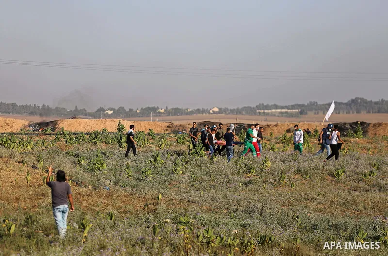 Palestinian protesters run for cover during clashes with Israeli security forces near the border fence east of Gaza City, on July 02, 2017. Photo by Mohammed Asad