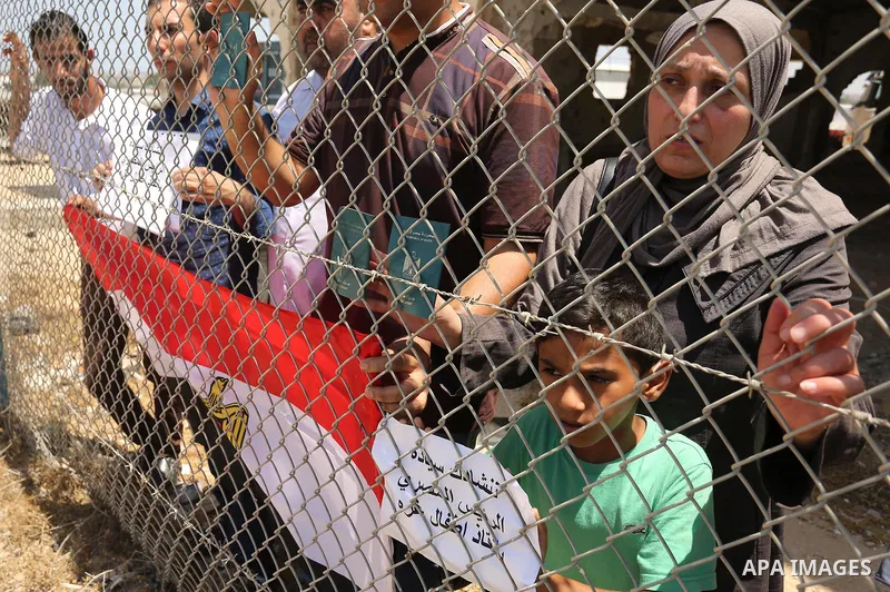Palestinians gather in front of the gate of Rafah border crossing between Egypt and Gaza during a protest against the blockade calling for reopening of the crossing, in the southern Gaza Strip July 3, 2017. Photo by Ashr...