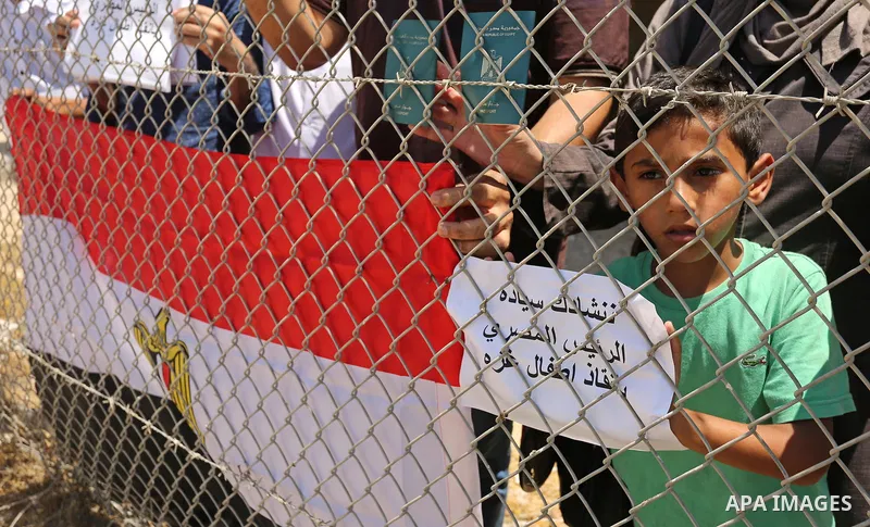 Palestinians gather in front of the gate of Rafah border crossing between Egypt and Gaza during a protest against the blockade calling for reopening of the crossing, in the southern Gaza Strip July 3, 2017. Photo by Ashr...