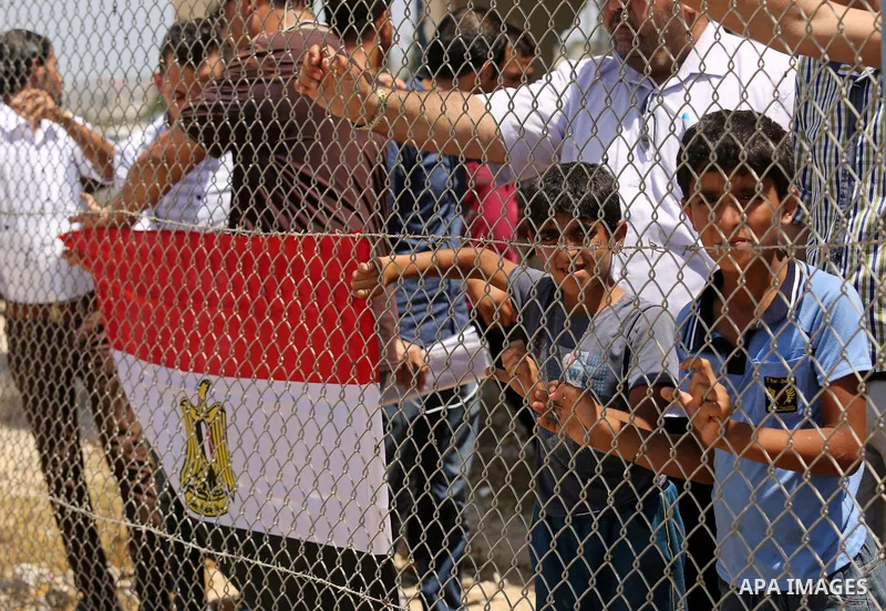 Palestinians gather in front of the gate of Rafah border crossing between Egypt and Gaza during a protest against the blockade calling for reopening of the crossing, in the southern Gaza Strip July 3, 2017. Photo by Ashr...