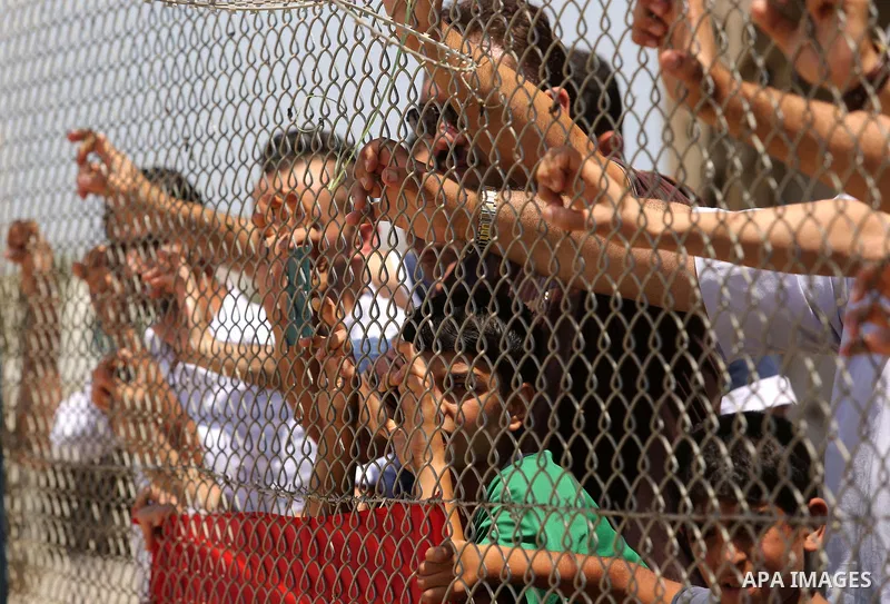 Palestinians gather in front of the gate of Rafah border crossing between Egypt and Gaza during a protest against the blockade calling for reopening of the crossing, in the southern Gaza Strip July 3, 2017. Photo by Ashr...