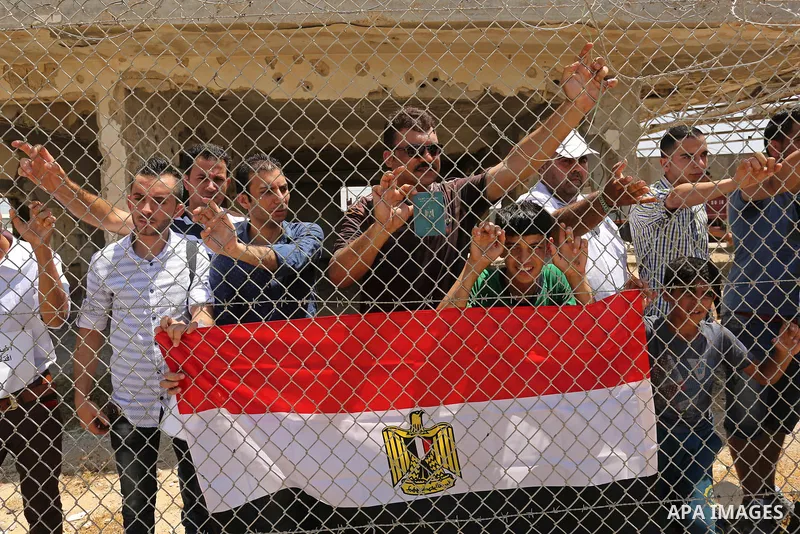 Palestinians gather in front of the gate of Rafah border crossing between Egypt and Gaza during a protest against the blockade calling for reopening of the crossing, in the southern Gaza Strip July 3, 2017. Photo by Ashr...