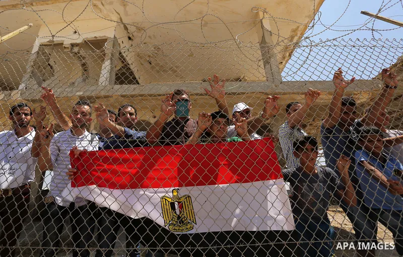 Palestinians gather in front of the gate of Rafah border crossing between Egypt and Gaza during a protest against the blockade calling for reopening of the crossing, in the southern Gaza Strip July 3, 2017. Photo by Ashr...