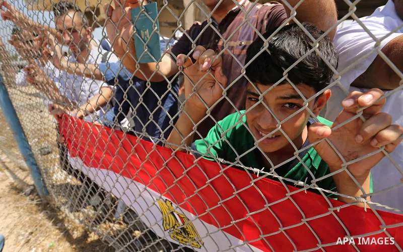 Palestinians gather in front of the gate of Rafah border crossing between Egypt and Gaza during a protest against the blockade calling for reopening of the crossing, in the southern Gaza Strip July 3, 2017. Photo by Ashr...